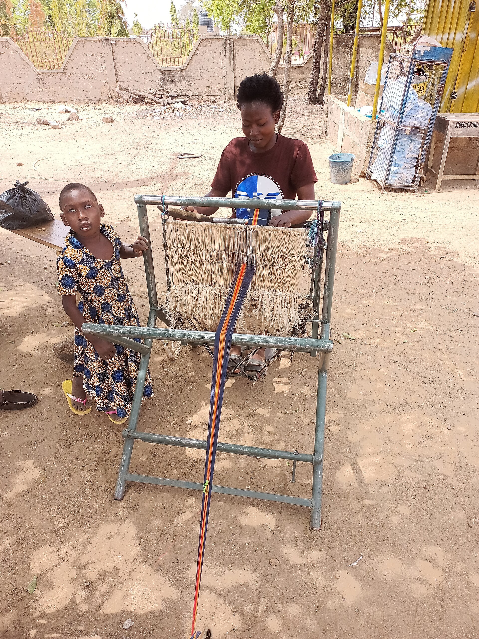A young woman weaving kente cloth